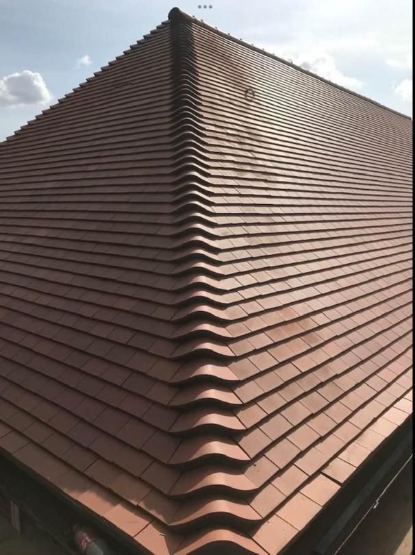 Newly tiled hipped roof completed by Aim High Roofing in Whitton